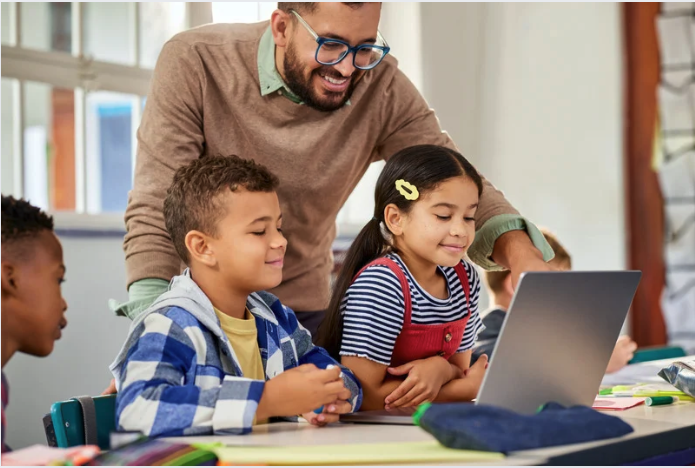 children using a laptop in a classroom