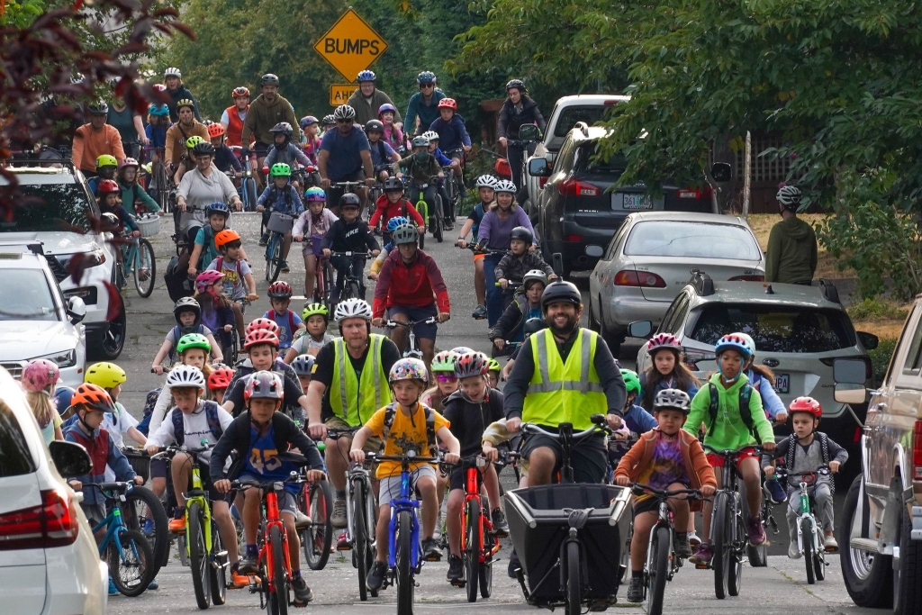 Sam Balto leading a large group of cyclists down a street