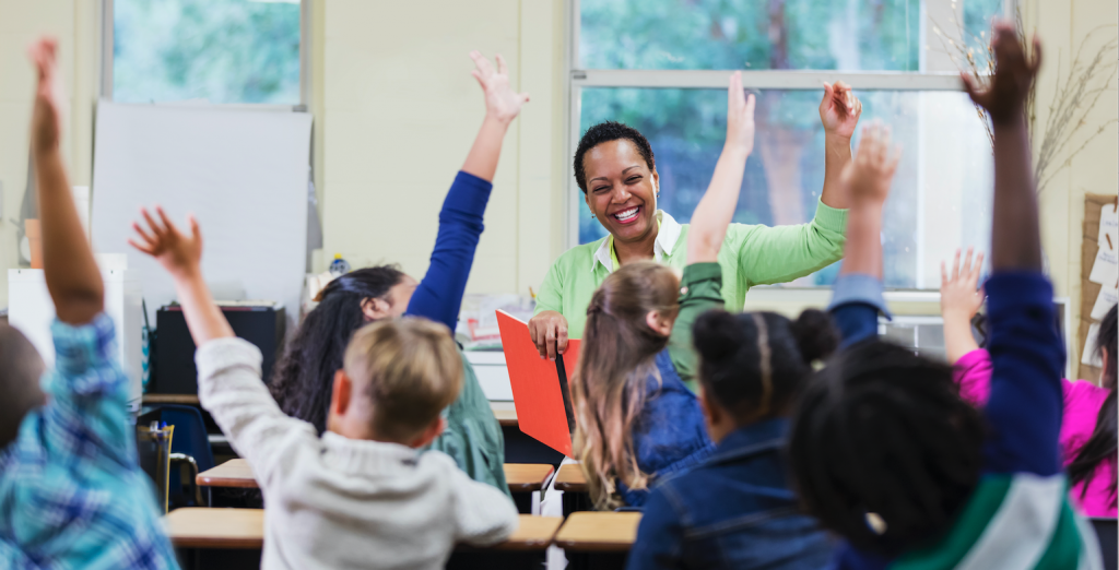 An%20African-American%20teacher%2C%20a%20mature%20woman%20in%20her%2040s%2C%20sitting%20in%20front%20of%20her%20class%20of%20elementary%20school%20students%2C%206%20and%207%20years%20old.png