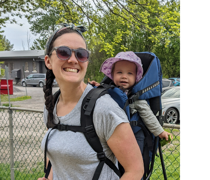 Ellen Long's profile picture shows that she and her child (sitting in a baby carrier on Ellen's back) are about to start a hike.