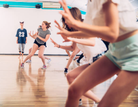 teenagers dancing on hardwood floor as a dance class in high school