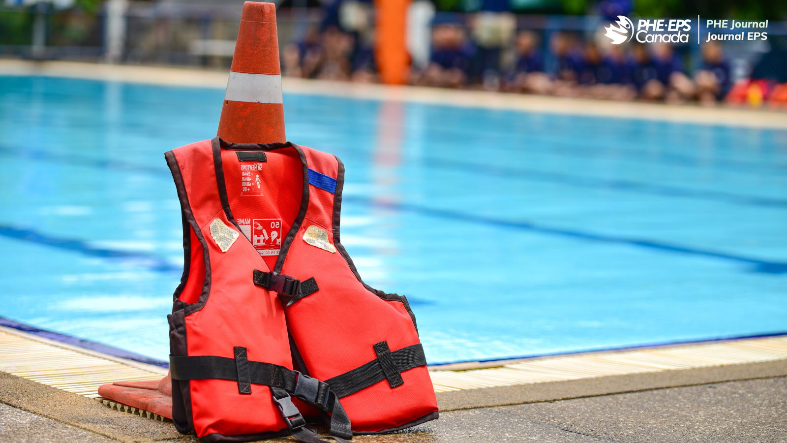The photo shows a lifejacket lying next to a safety cone next to a swimming pool