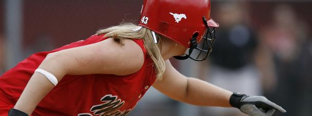 a girl with blond hair playing baseball - she is wearing a red helmet, red tank jersey and black and white gloves. 