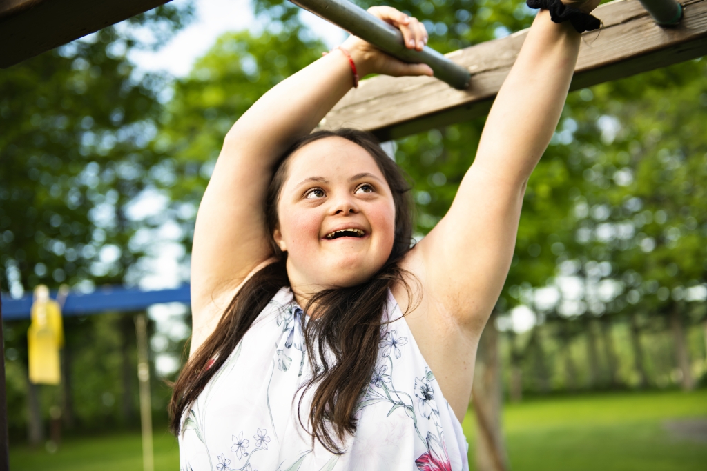 portrait of trisomie 21 adult girl outside at sunset having fun on a park