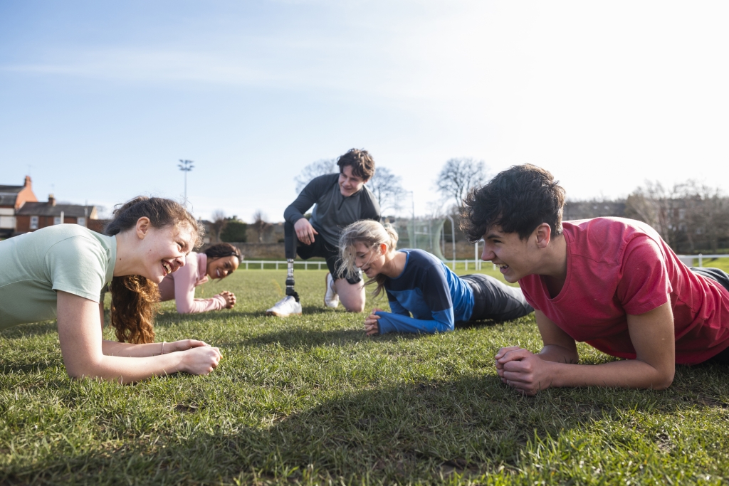 a group of students with all ability levels exercising on an green field.