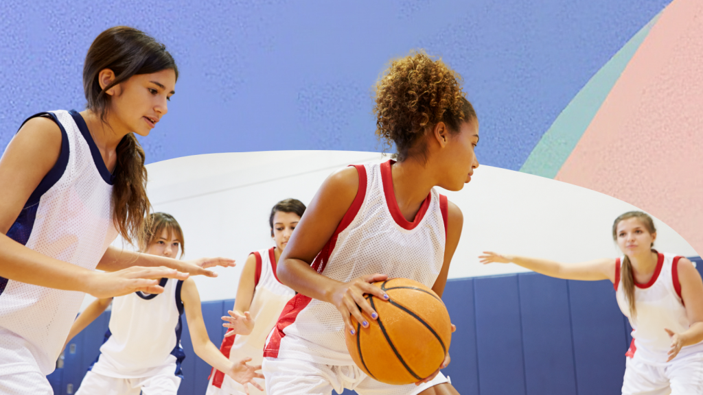 A group of girls playing basketball in a school gym, looking confident.