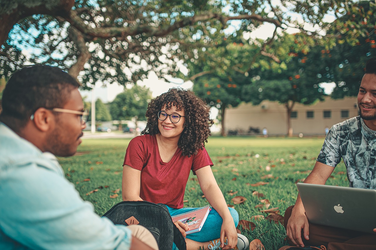 The photo is showing three young people talking and looking relaxed.