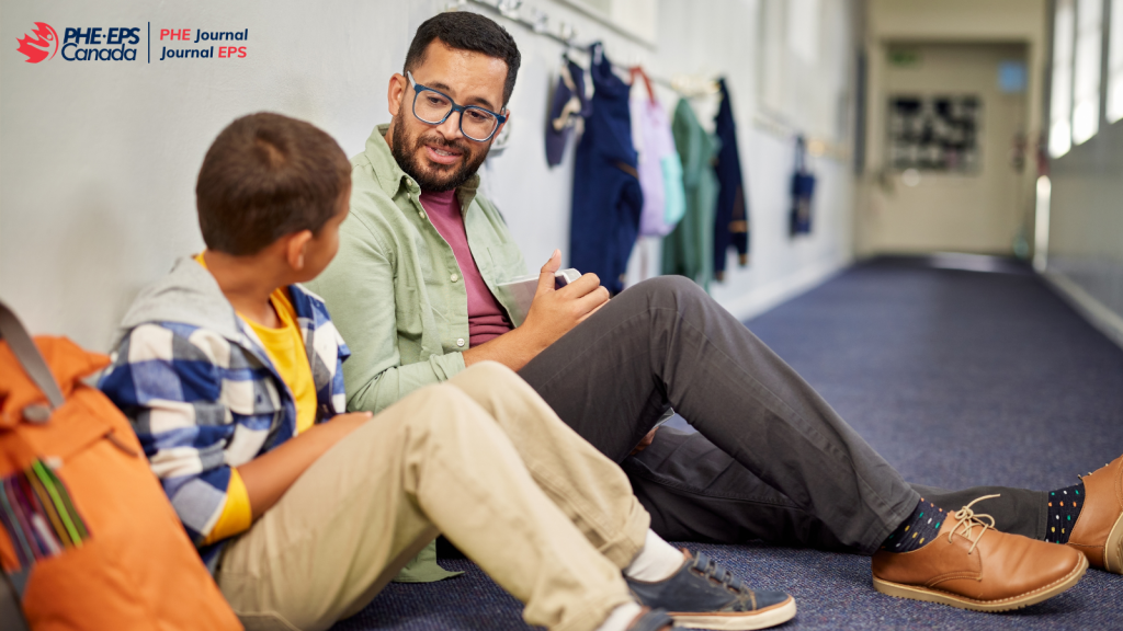 The image is showing a teacher connecting with a student by engaging a friendly conversation in a school hallway.