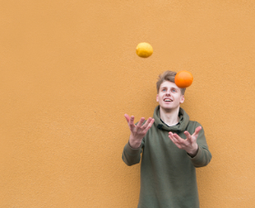 teenager juggling two fruit items