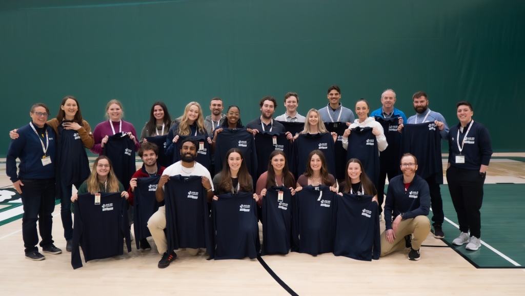 group of people holding up shirts that say "PHE Canada Student Chapter"