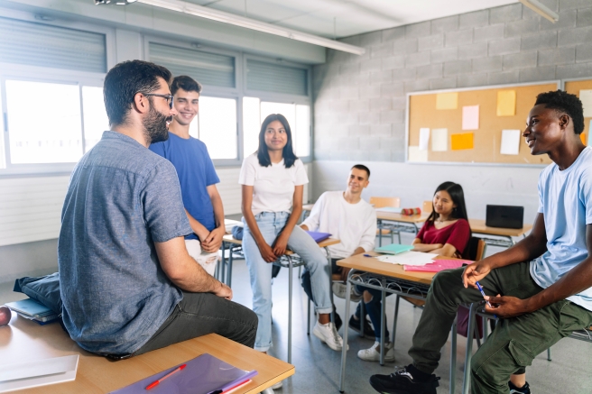 5 students in front of their teacher in a classroom