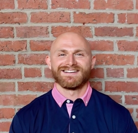 photo of Dyson wearing a dark blue shirt with a pink collar. 