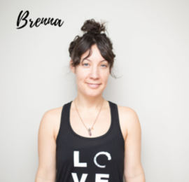middle aged, white woman, with dark brown hair up in a bun with split bangs covering her forehead. She is wearing a black tank top that says 'love'. 