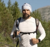 Photo of JJ outdoors wearing a backpack and toque. 