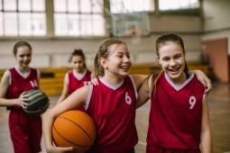 2 girls holding each other by the shoulders in basketball gear - 2 jeunes filles se tenant par les épaules en tenue de basketball