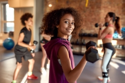 The photo is showing a girl doing weightlifting with a dumbbell.