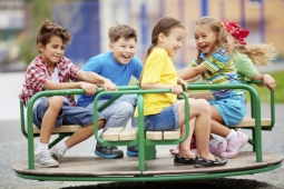 4 children spinning on playground equipment