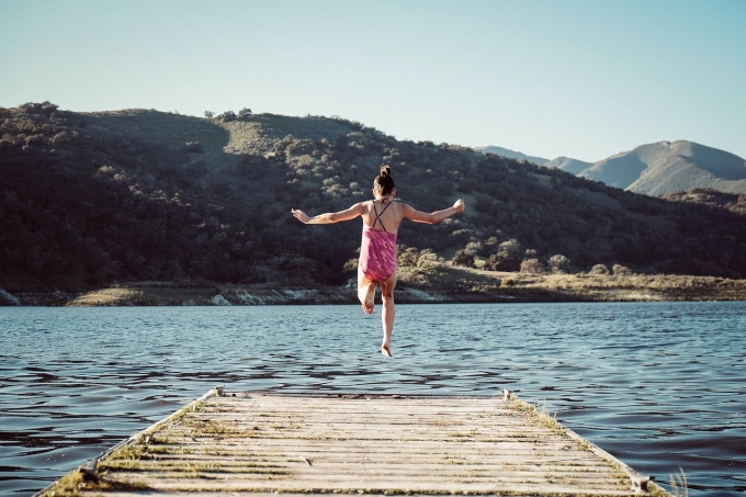 Girl jumping off a dock for fun