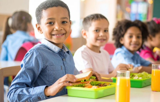 A group of kids enjoying the food in schools.